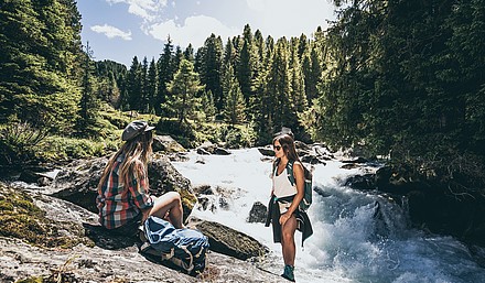 Zwei Wanderer rasten am Fluss in der Zillertal Arena