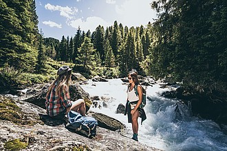 Zwei Wanderer rasten am Fluss in der Zillertal Arena