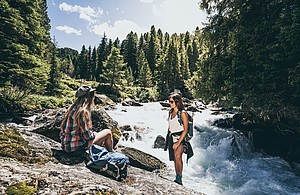 Zwei Wanderer rasten am Fluss in der Zillertal Arena